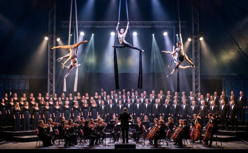 Dramatic performance of Cirque des Voix® inside a circus tent with a 100+ voice choir and aerialists.