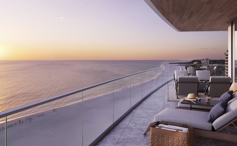 A luxurious outdoor balcony at Rosewood Residences Lido Key overlooking a beach and ocean at sunset.