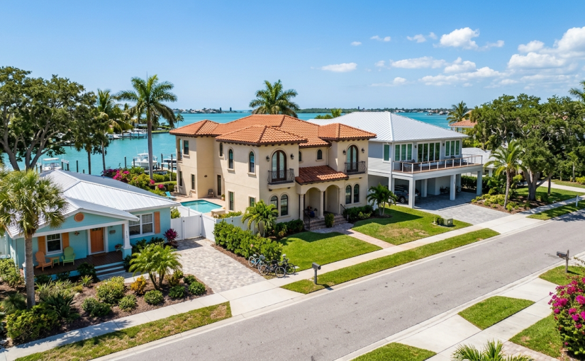 Aerial view of luxury waterfront real estate and coastal investment properties in Sarasota, Florida, showcasing Mediterranean and modern architectural styles.